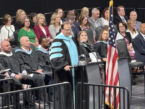 Superintendent Dr. Ed Nichols addressing graduates from stage
